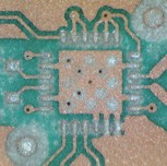 Magnified view showing pitting on the PCB surface